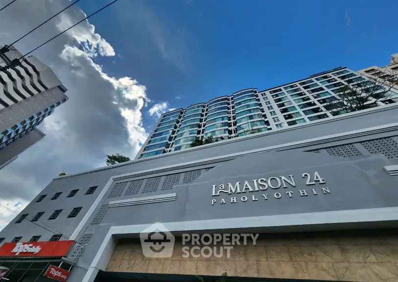 Modern high-rise building La Maison 24 Paholyothin with clear blue sky