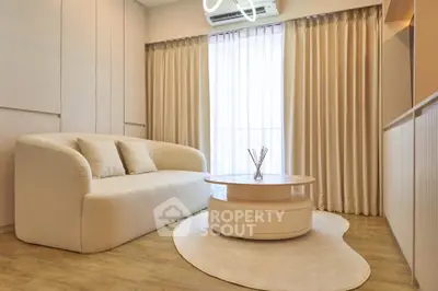 Elegant living room with modern beige sofa, round coffee table, and soft lighting, perfect for cozy relaxation.
