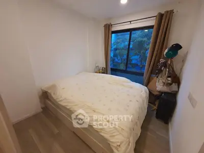 Cozy bedroom with large window and modern decor in a stylish apartment.