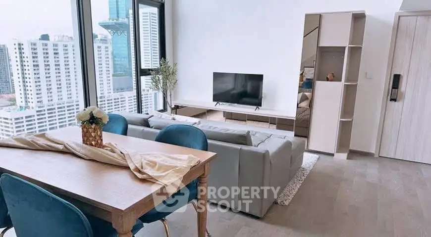 Modern living room with city view, stylish furniture, and large windows in urban apartment.