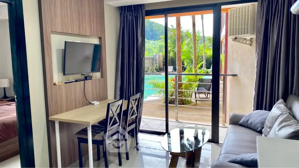 Modern living room with pool view, stylish furniture, and natural light in a luxury apartment.