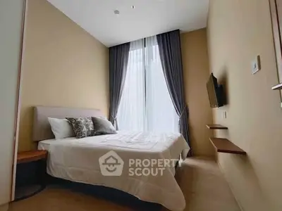 Modern bedroom with large window and wall-mounted TV in a cozy apartment.