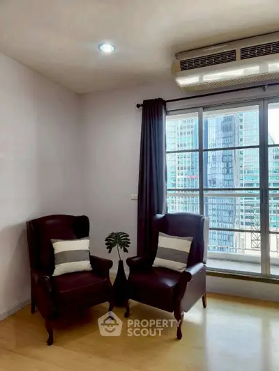Cozy corner with two leather chairs and city view window in modern apartment.