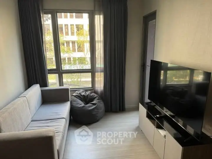 Cozy living room with modern sofa and large TV, perfect for relaxation.