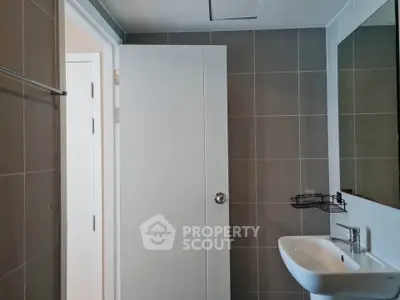 Modern bathroom with sleek sink and open door in contemporary apartment.