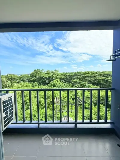 Stunning balcony view overlooking lush greenery and blue skies, perfect for relaxation.