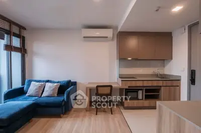 Modern living room with blue sofa and compact kitchen area