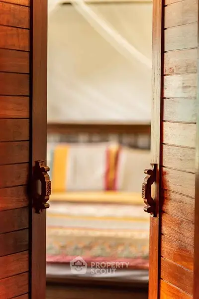Cozy bedroom with wooden doors and colorful bedding, perfect for a serene retreat.