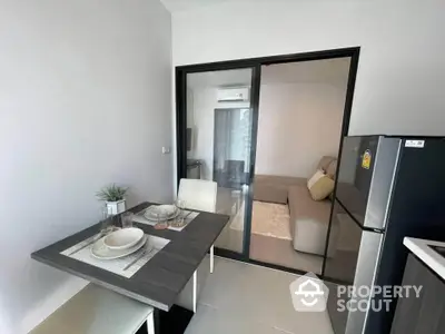 Modern dining area with sleek table and chairs next to a cozy living room in a stylish apartment.