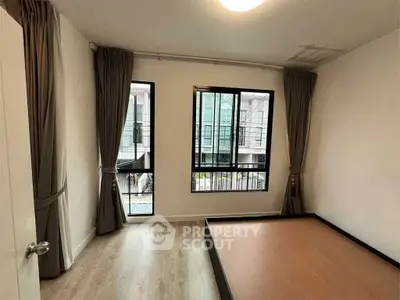 Spacious bedroom with large windows and modern design in a stylish apartment.