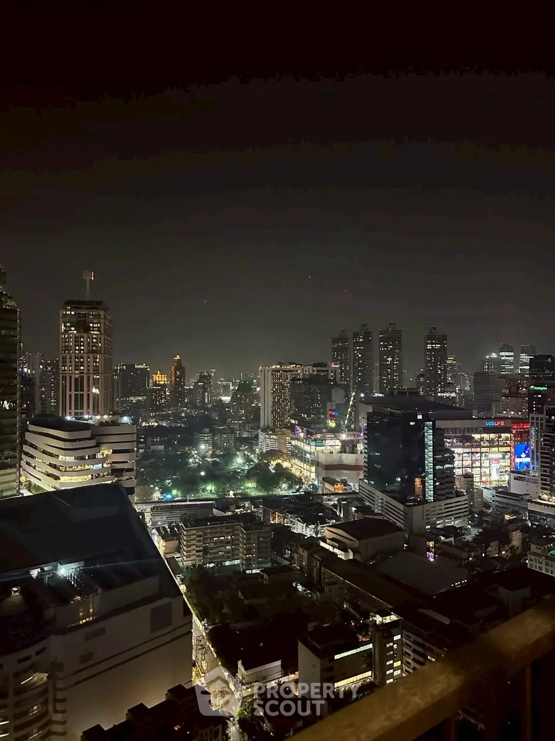 Stunning night cityscape view from a high-rise balcony, showcasing vibrant city lights and skyline.