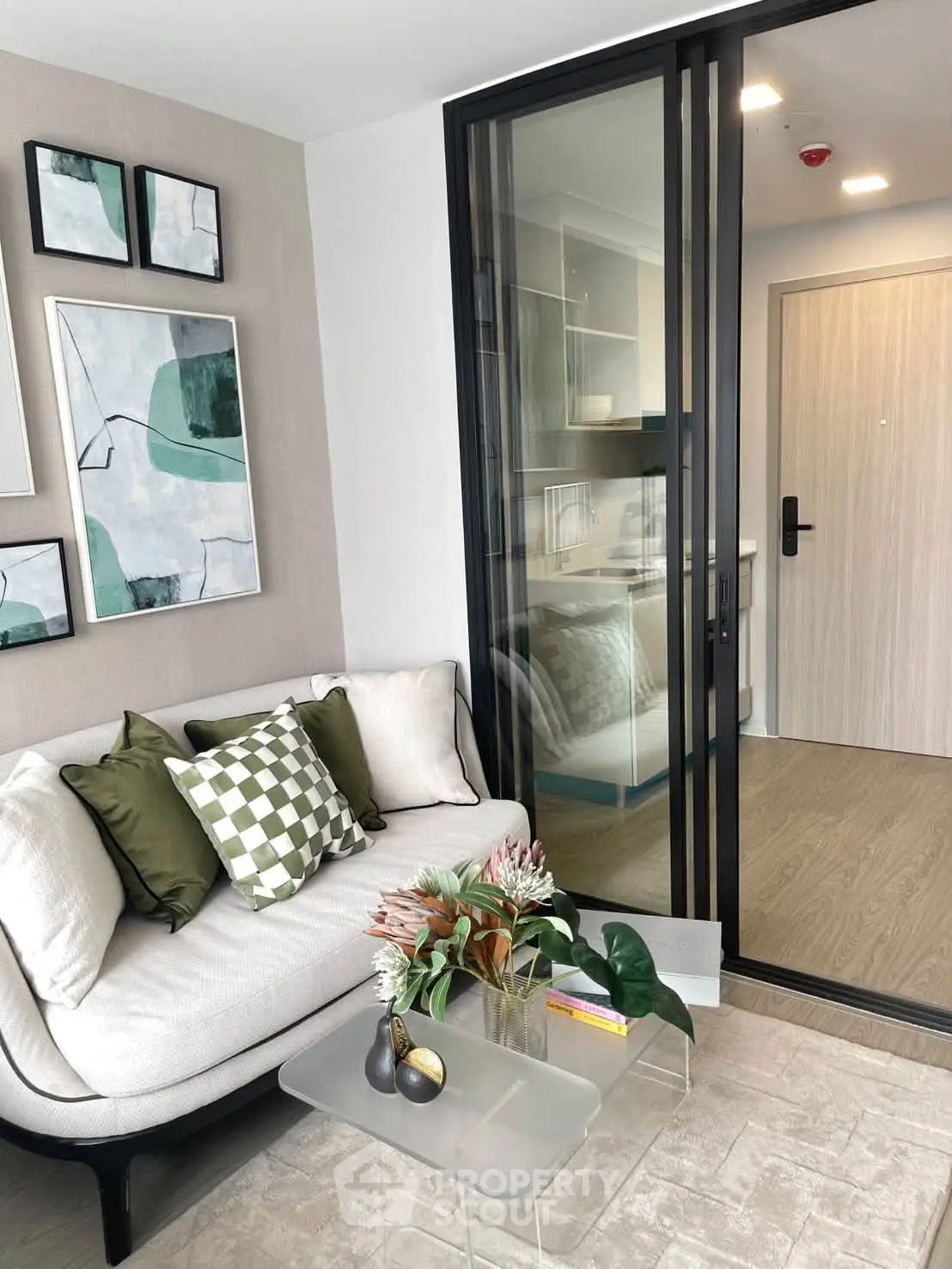 Modern living room with stylish decor and sliding glass door leading to kitchen area.
