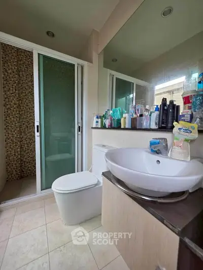 Modern bathroom with sleek fixtures and glass shower enclosure.