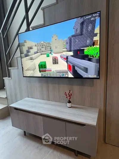 Modern living room with wall-mounted TV and sleek storage unit under staircase