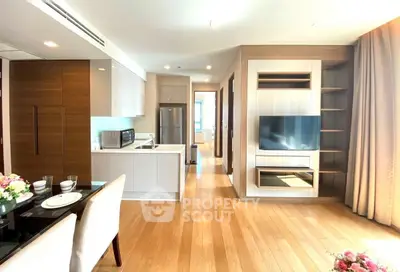 Modern open-plan living room with sleek kitchen and dining area, featuring hardwood floors and contemporary design.