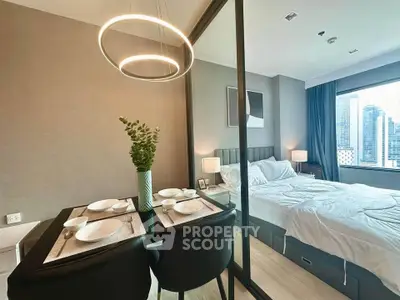 Modern bedroom with dining area and city view, featuring elegant lighting and stylish decor.