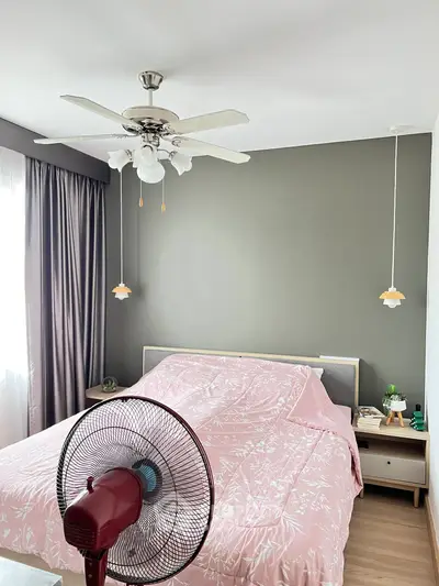 Cozy bedroom with stylish decor and ceiling fan, featuring a comfortable bed and natural light.