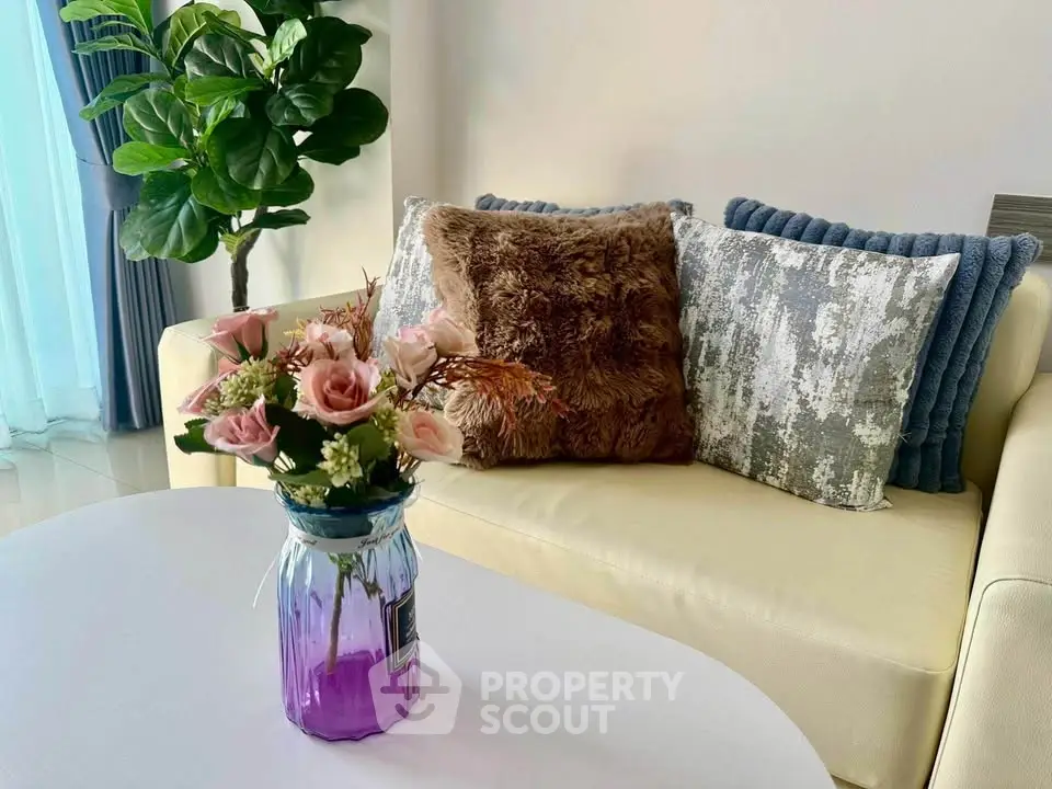 Chic living room with cozy sofa, plush cushions, and elegant floral arrangement, perfect for relaxation.