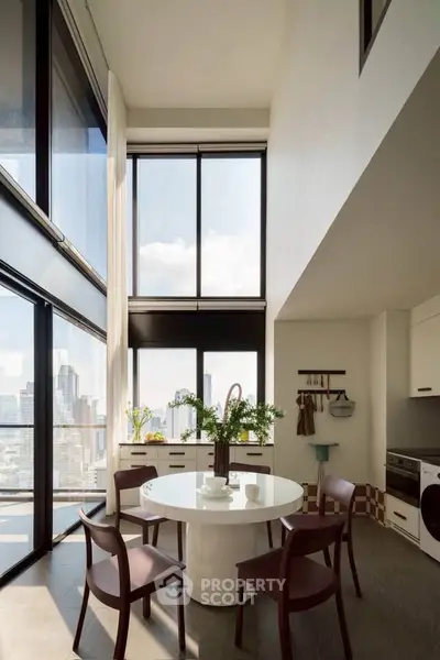 Stunning modern kitchen with high ceilings and panoramic city views, featuring sleek furniture and abundant natural light.