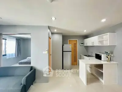 Modern open-plan living room and kitchen with sleek design and natural light