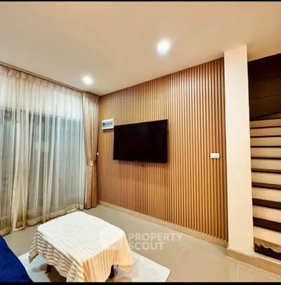 Modern living room with stylish wood panel wall and sleek staircase