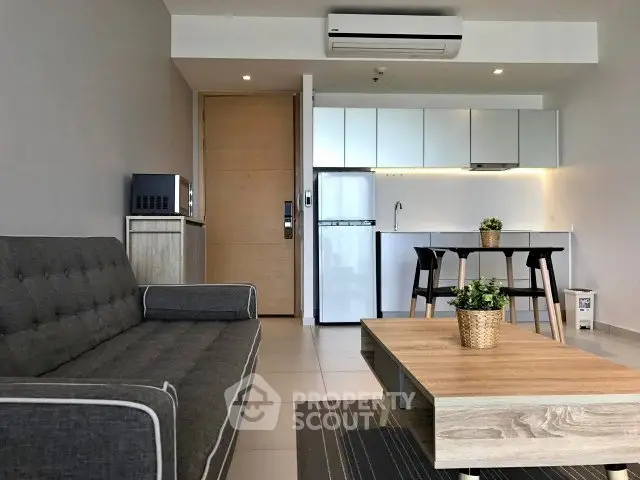 Modern living room with sleek kitchen, stylish furniture, and contemporary design in open layout apartment.