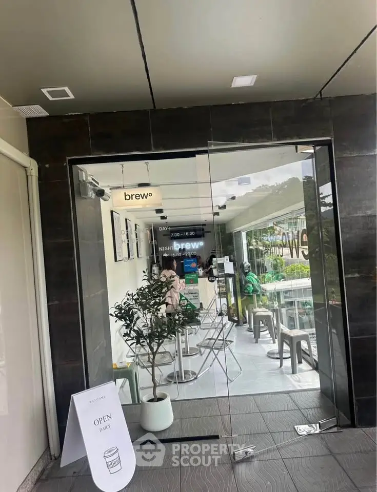 Chic cafe entrance with glass doors and modern seating, perfect for social gatherings.