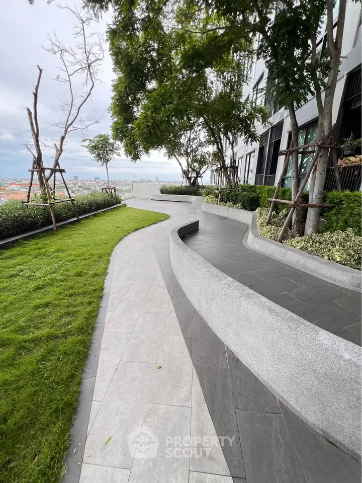 Modern building exterior with lush garden and scenic pathway offering serene views.
