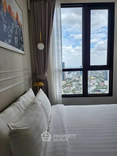 Luxurious bedroom with stunning city view from high-rise window, elegant decor and plush bedding.