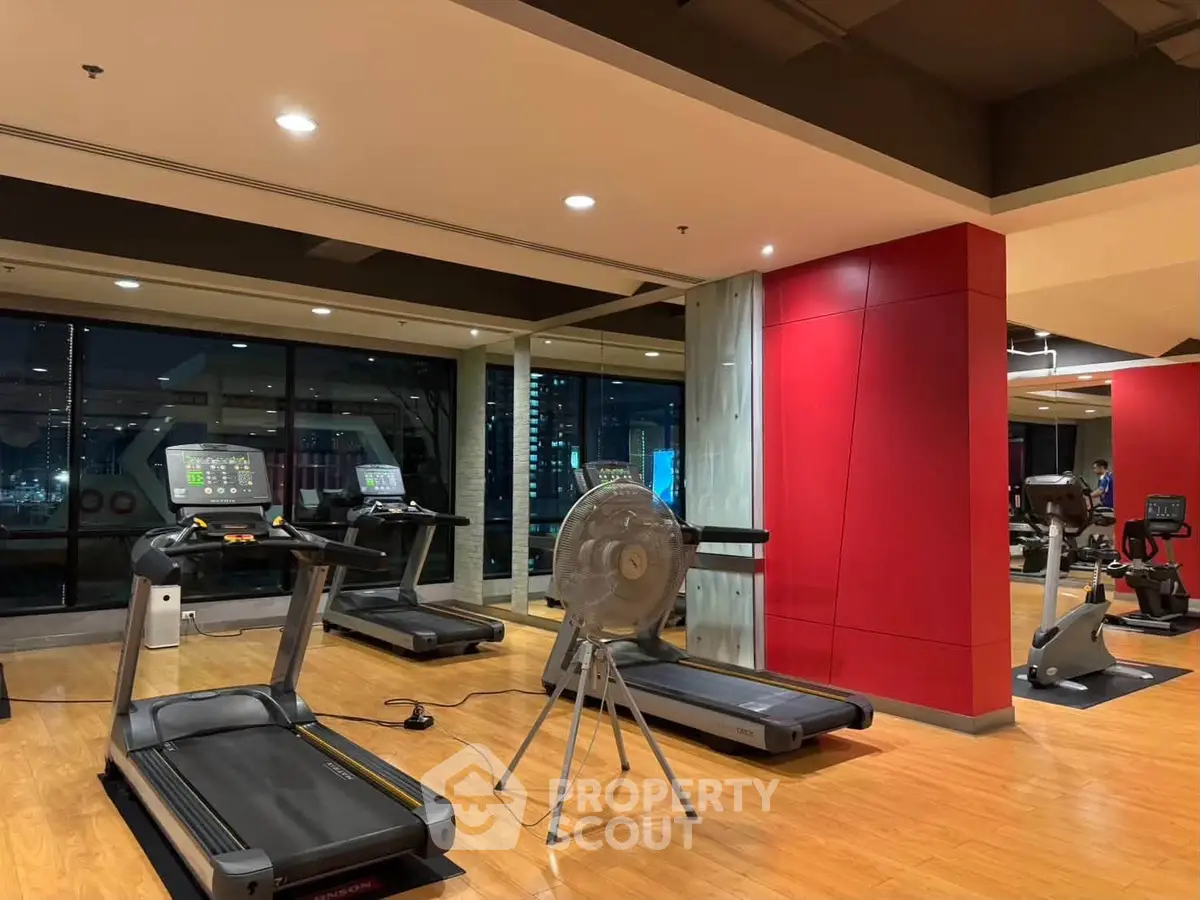 Modern gym with treadmills and city view, perfect for fitness enthusiasts seeking convenience and style.
