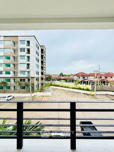 Spacious balcony view overlooking modern residential complex and parking area.