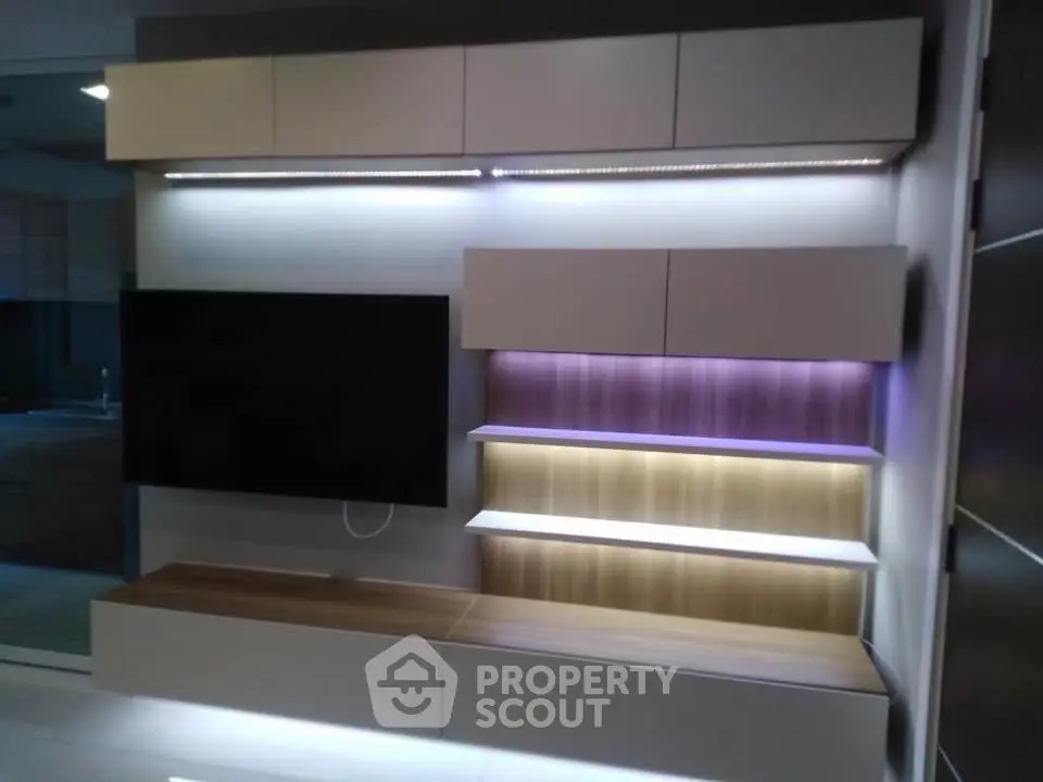 Modern living room with sleek wall-mounted TV and stylish shelving unit.