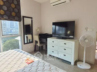 Cozy bedroom with city view, featuring a TV, dresser, and study desk, perfect for urban living.