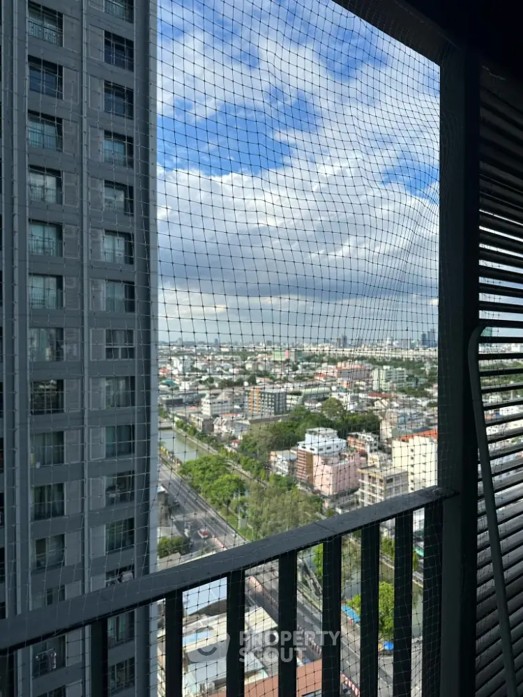 Stunning high-rise balcony view overlooking cityscape with blue sky and clouds.