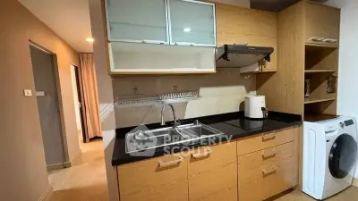 Modern kitchen with wooden cabinets, sleek countertops, and built-in appliances in a cozy apartment.
