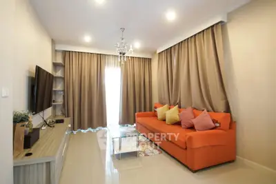 Spacious living room with modern decor and vibrant orange sofa