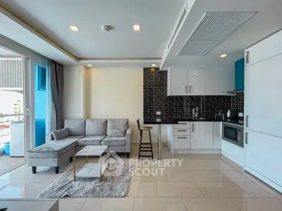 Modern open-plan living room with sleek kitchen and cozy seating area