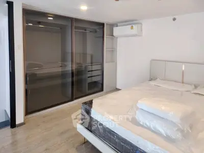 Modern bedroom with sleek wardrobe and air conditioning in stylish apartment.