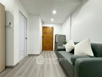 Modern living room with sleek flooring and cozy sofa in a minimalist apartment.