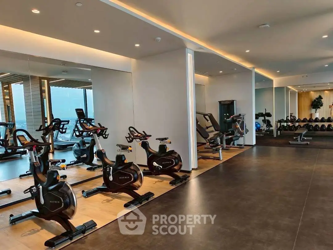 Modern gym with state-of-the-art equipment and mirrored walls in luxury real estate property.