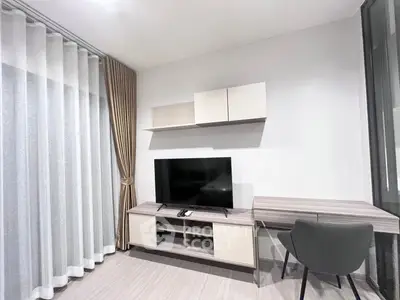 Modern living room with sleek TV stand and elegant curtains in a stylish apartment.