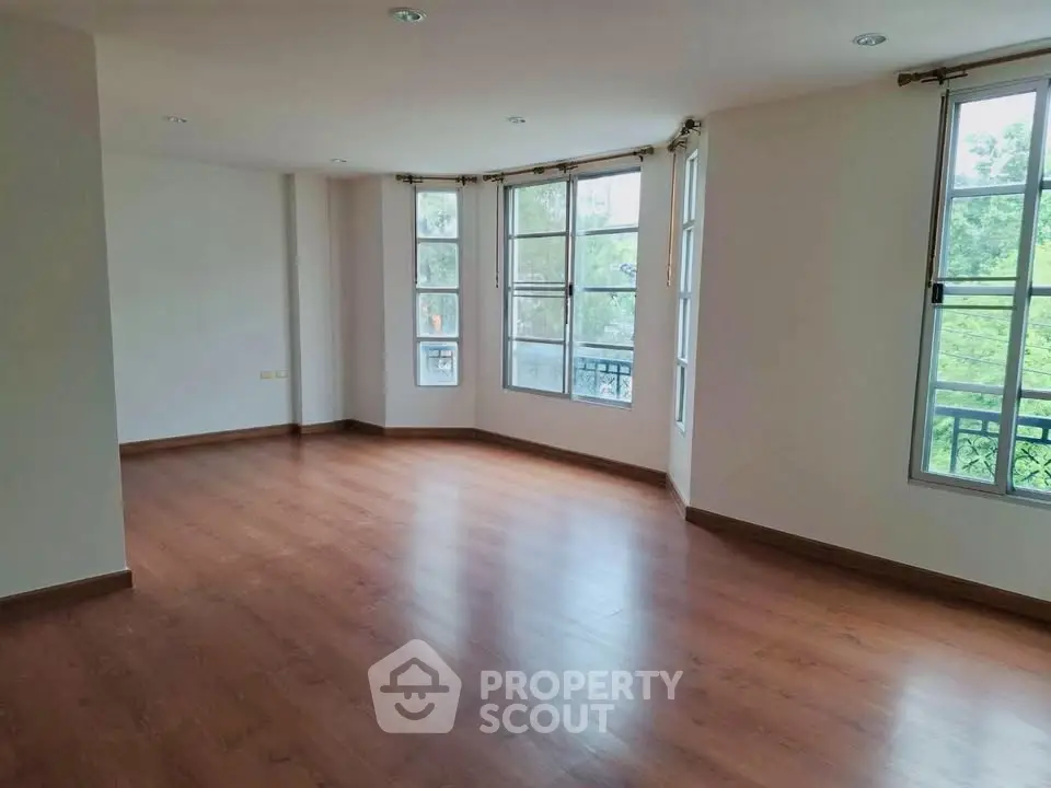 Spacious corner unit with large windows and wooden flooring, offering abundant natural light and serene views.