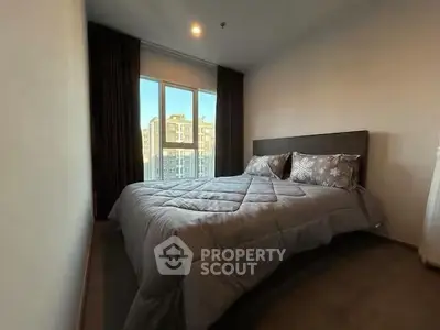 Cozy bedroom with large window offering city view, featuring a comfortable bed and elegant decor.