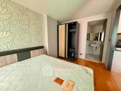 Modern bedroom with stylish wallpaper and ensuite bathroom in a cozy apartment.