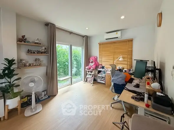 Spacious study room with large window and modern decor, perfect for productivity and relaxation.