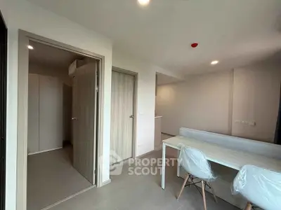 Modern apartment interior with dining area and hallway, featuring sleek design and neutral tones.