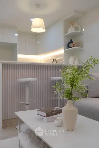 Modern kitchen with open layout and stylish decor, featuring a cozy seating area and elegant lighting.