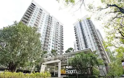 Modern high-rise residential building with lush greenery and elegant entrance