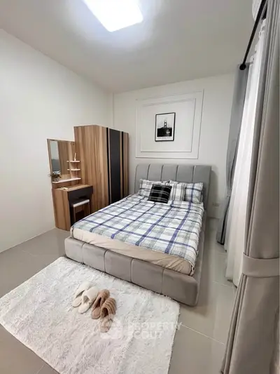 Cozy bedroom with modern decor and plush bedding in a stylish apartment.