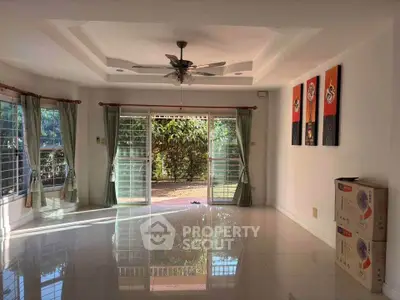 Spacious living room with large windows and garden view, perfect for natural light lovers.